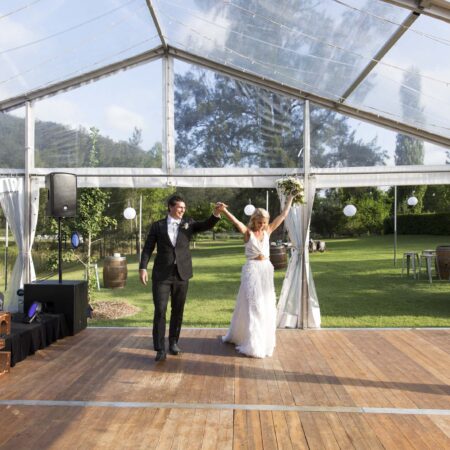 Bride and Groom on Timber Dance Floor under Clear Hocker Marquee
