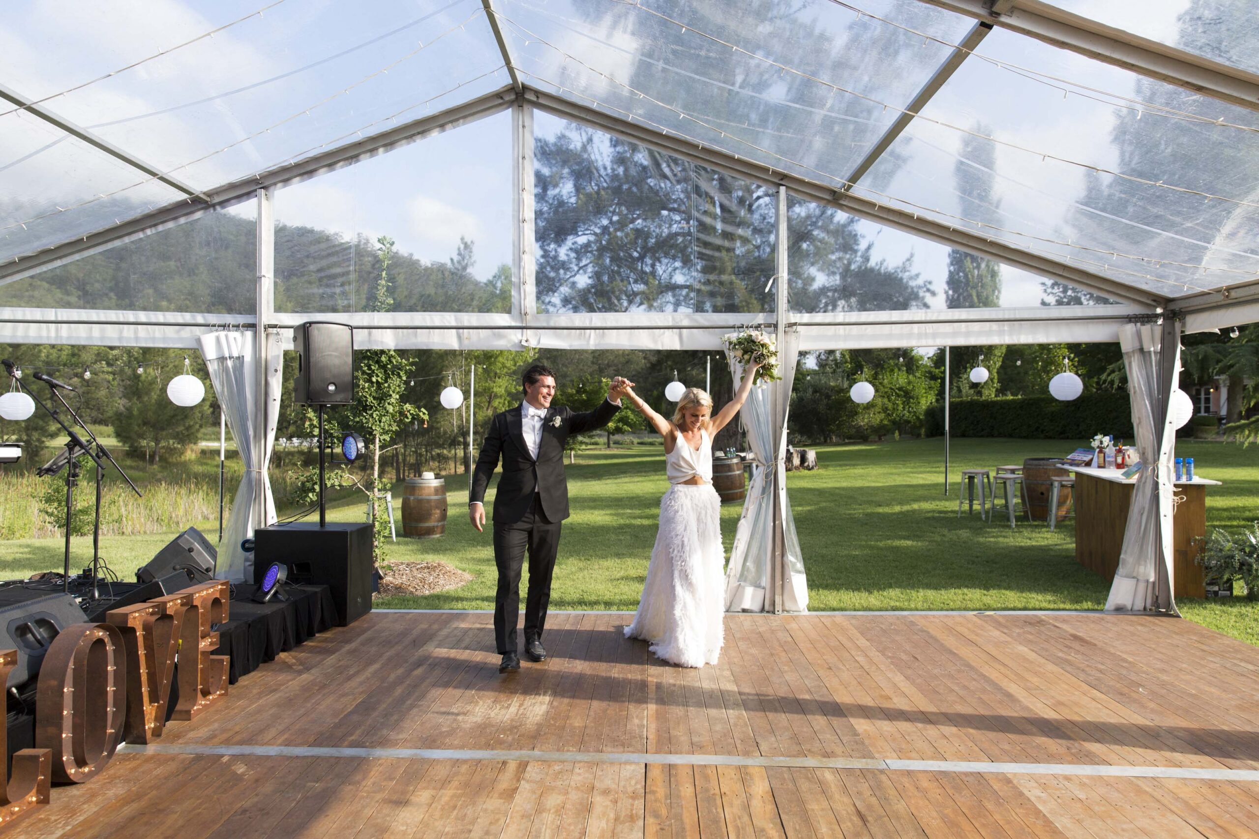 Bride and Groom on Timber Dance Floor under Clear Hocker Marquee