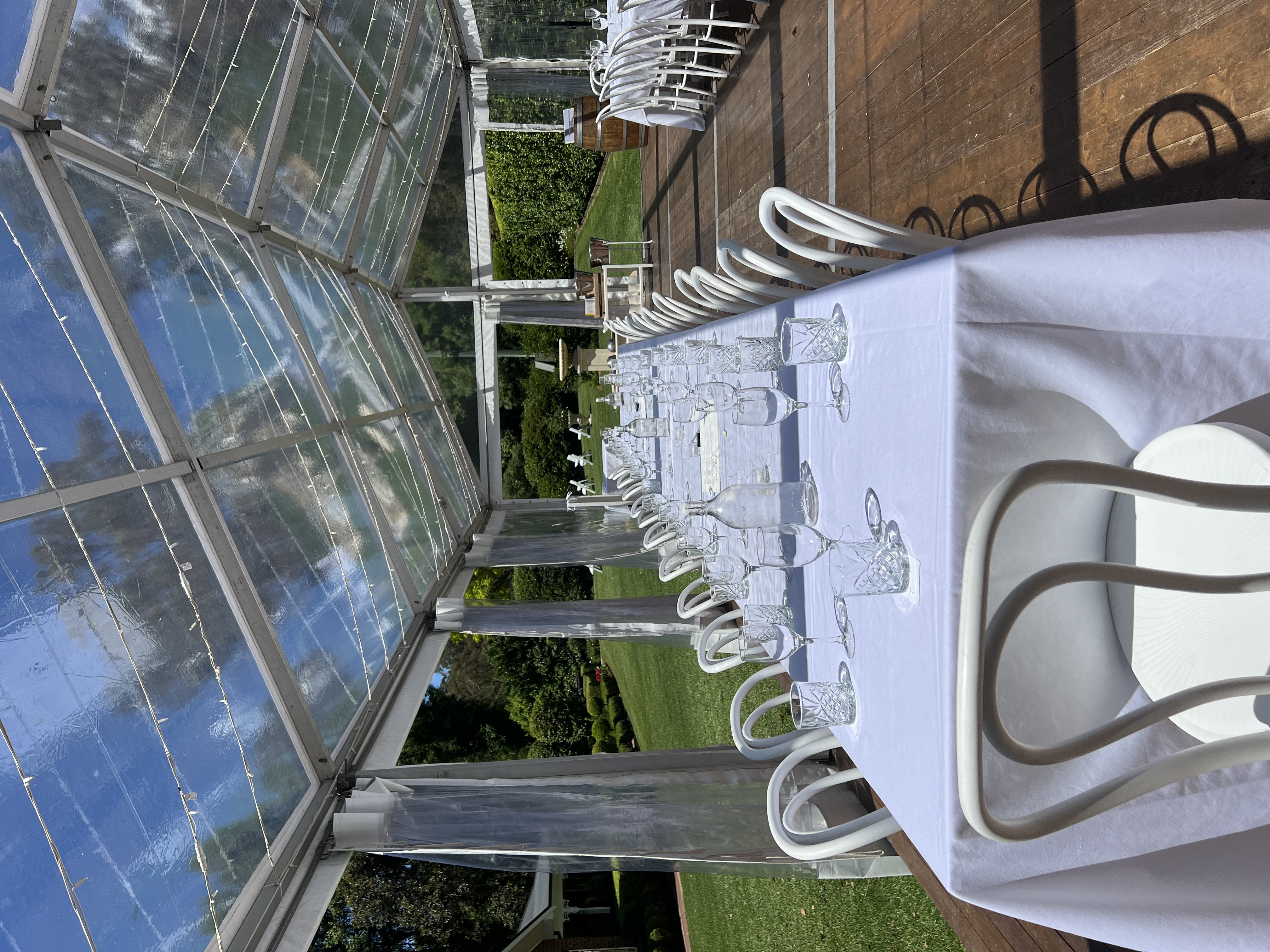 Clear Hocker Marquee in Garden with White Bentwood Chairs, Tablecloths and Timber Flooring