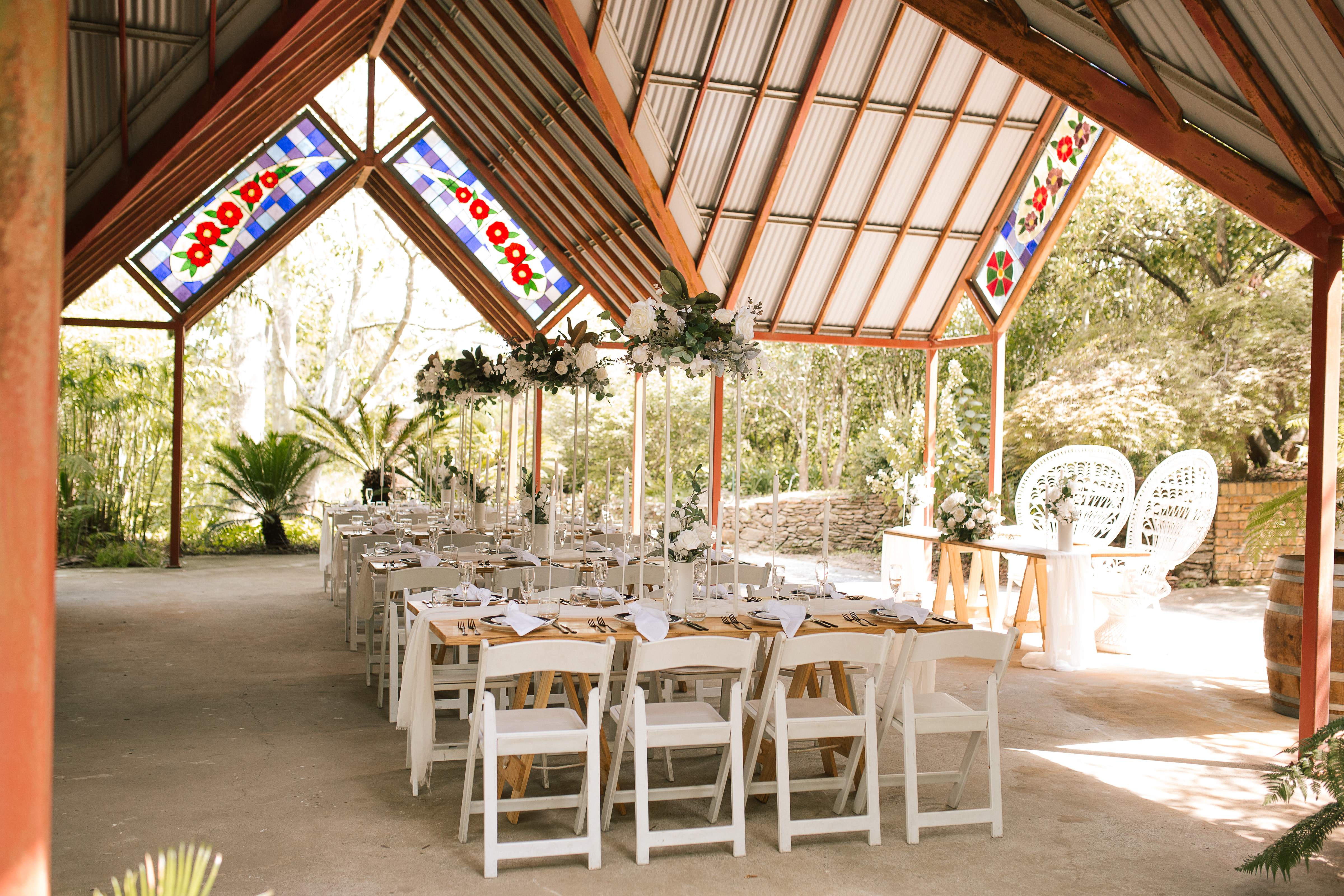 Wedding reception table setting with white chairs in paradise gardens