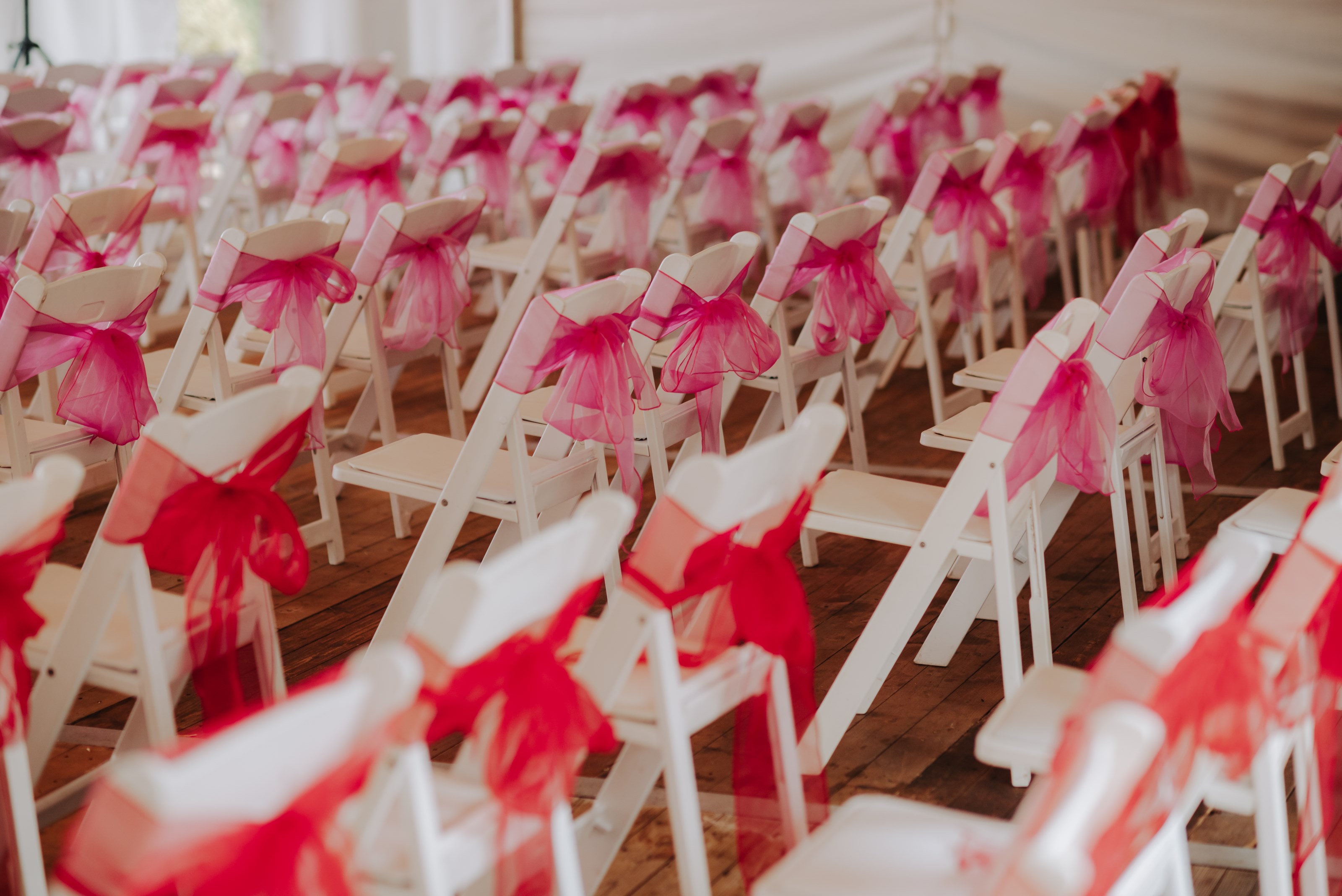 White Wedding Ceremony Chairs with Pink Ribbon Accents