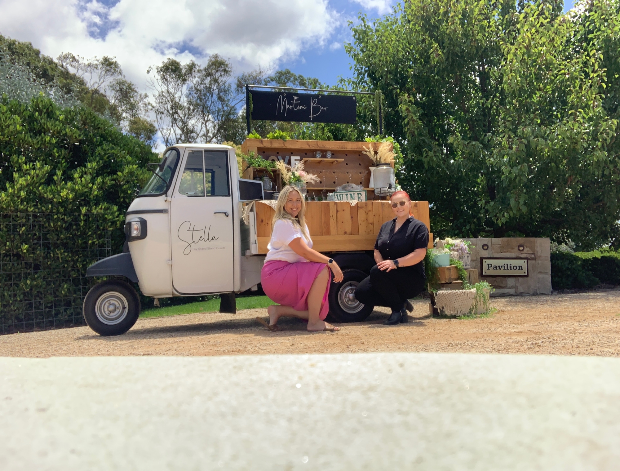Stella the Piaggio Ape our Boho Styled Hospitality Vehicle in a Garden with our Team