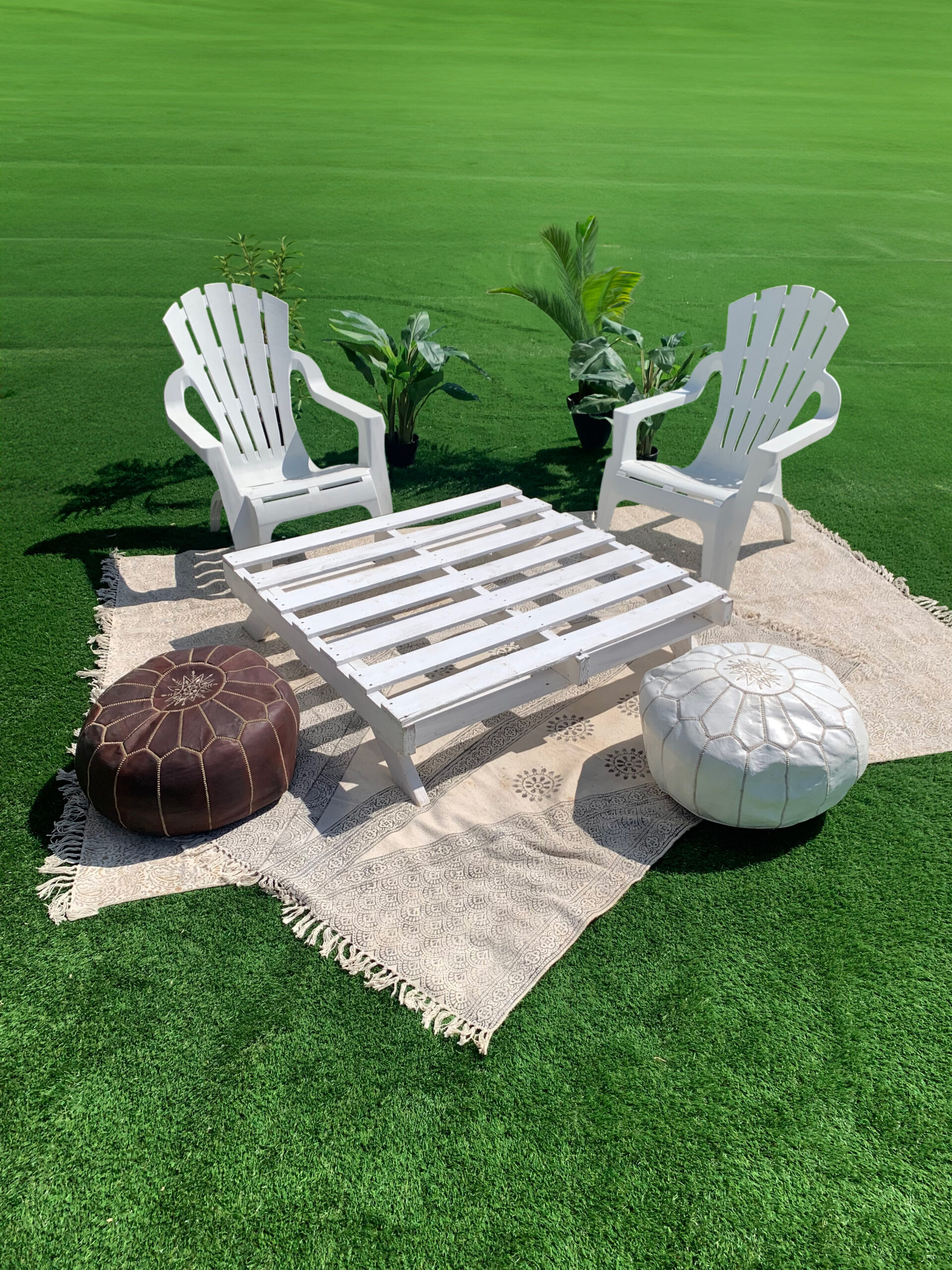 Pallet Picnic Table on grass styled with boho rugs, Moroccan ottomans and chairs for picnic setting