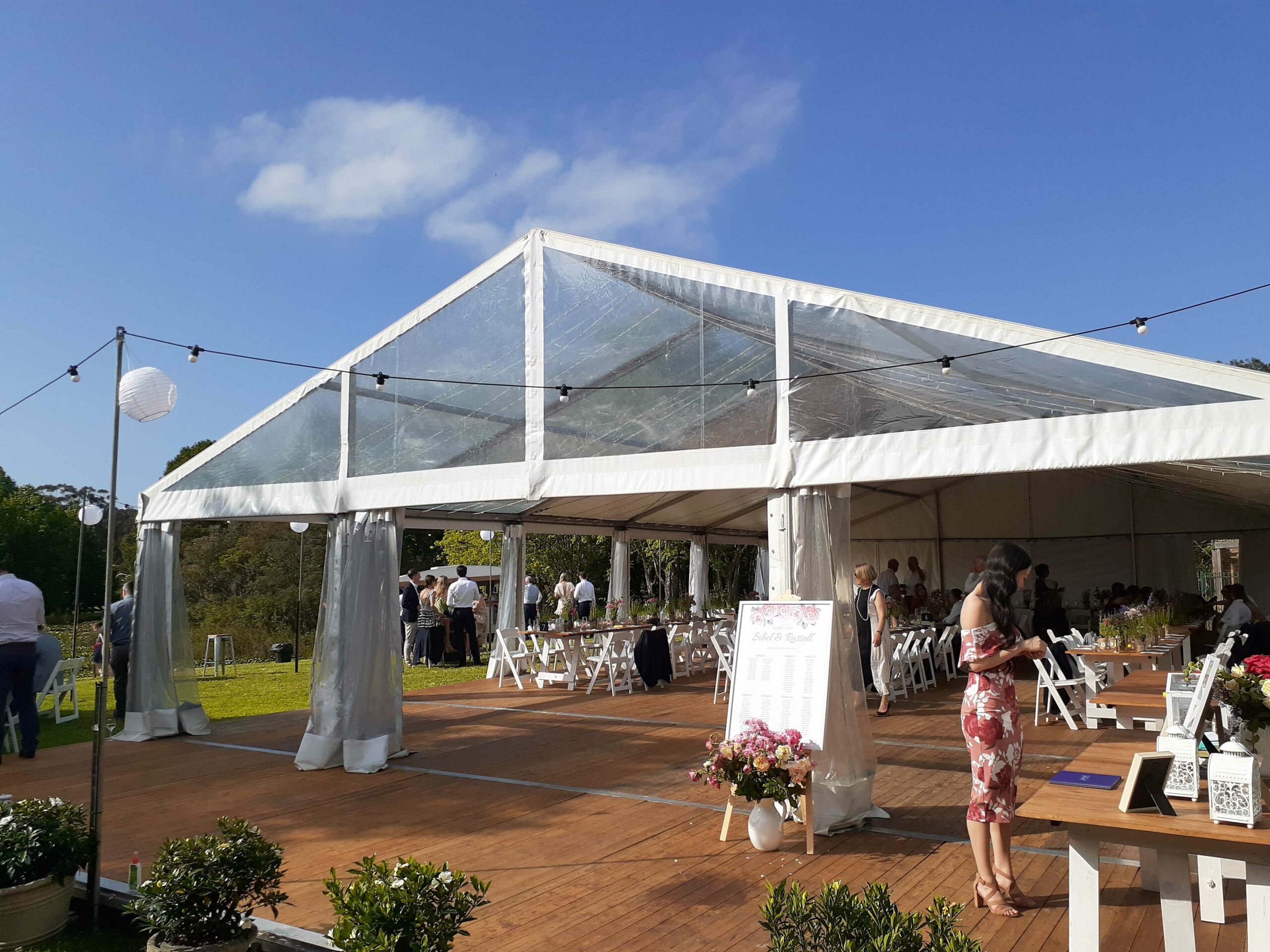 Fully integrated timber flooring with extension for danceloor, table, chairs and clear marquee.